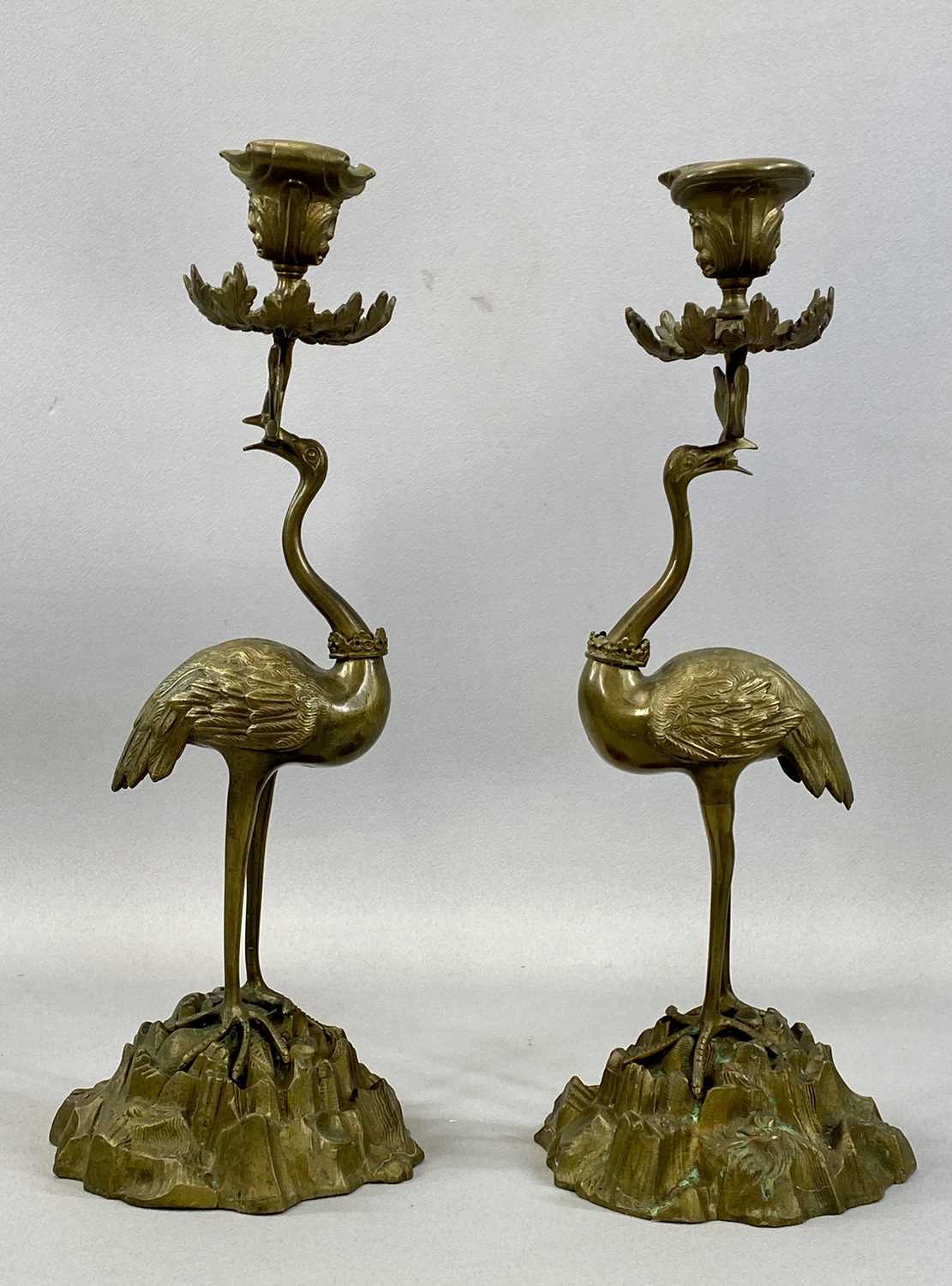 PAIR OF REGENCY STYLE BRASS CANDLESTICKS modelled as cranes standing on naturalistic bases,