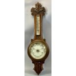 EDWARDIAN OAK CASED ANEROID BAROMETER with carved detail, circular porcelain dial with