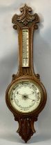 EDWARDIAN OAK CASED ANEROID BAROMETER with carved detail, circular porcelain dial with