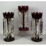 VICTORIAN RUBY GLASS LUSTRES A PAIR, with gilded highlights and clear cut glass drops, 34.5cms (h)
