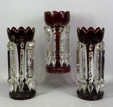 VICTORIAN RUBY GLASS LUSTRES A PAIR, with gilded highlights and clear cut glass drops, 34.5cms (h)