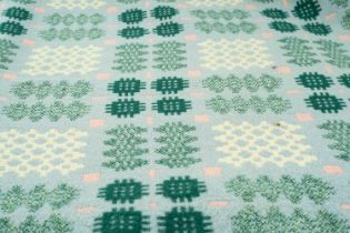 TRADITIONAL WELSH WOOLEN BLANKET of geometric design, pale blue ground with white, pink and green