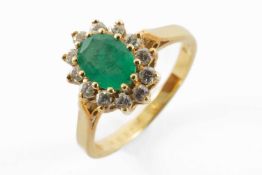 EMERALD & DIAMOND RING, oval emerald appr. 8 x 5mm within border of 12 small diamonds mounted in