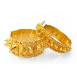 TWO SIMILAR YELLOW METAL MIDDLE EASTERN BANGLES, of pointed conical design, with maker's initials,