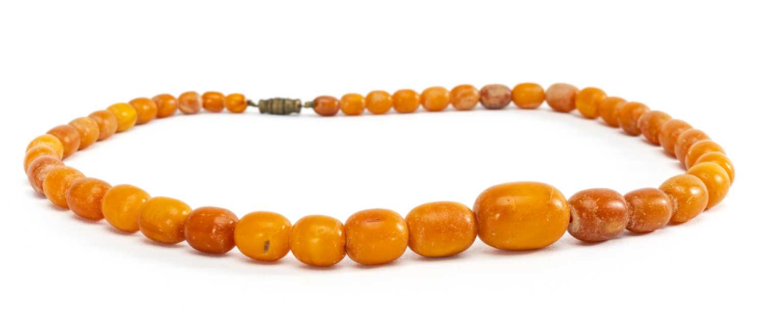 PRESUMED BALTIC AMBER BEAD NECKLACE, strung with graduated oapque oval beads from 20mm to 5mm