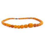 PRESUMED BALTIC AMBER BEAD NECKLACE, strung with graduated oapque oval beads from 20mm to 5mm