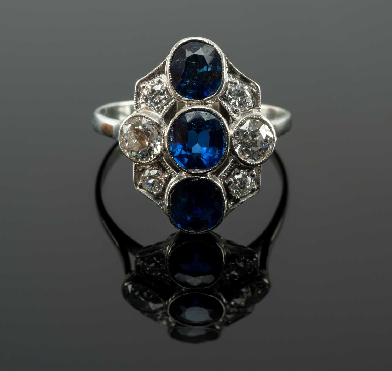 WHITE METAL SAPPHIRE & DIAMOND CLUSTER RING, the three vertical sapphires complimented by six old