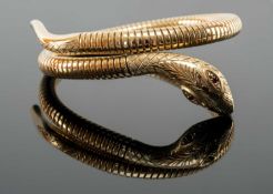 9CT GOLD COILED SNAKE BANGLE, the snake head terminal set with two ruby eyes, 26.3gms Provenance: