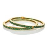 TWO SIMILAR YELLOW METAL BELIEVED EMERALD SET HINGED BANGLES, one stamped '22K' the other stamped '