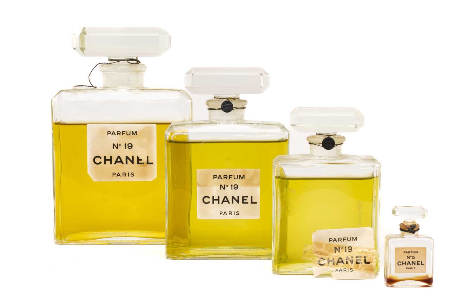 VINTAGE PERFUME comprising three graduated glass bottles of 'Chanel No 19 Parfum Paris' with