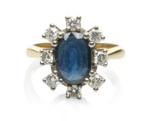 YELLOW METAL SAPPHIRE & DIAMOND CLUSTER RING, the central oval sapphire (9 x 7mms) with a border