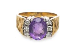 18CT GOLD AMETHYST & DIAMOND CLUSTER RING, the central oval amethyst (9 x 6mms) complimented by