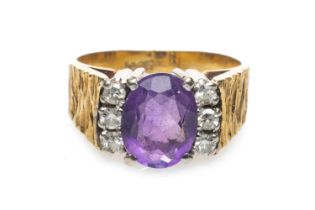 18CT GOLD AMETHYST & DIAMOND CLUSTER RING, the central oval amethyst (9 x 6mms) complimented by