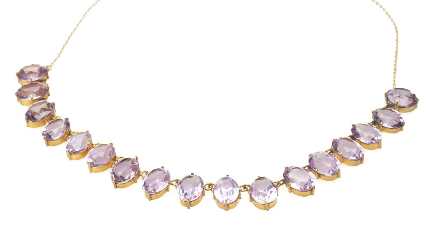 AMETHYST NECKLACE, seventeen pale oval cut stones in gold plated settings, suspended from gold