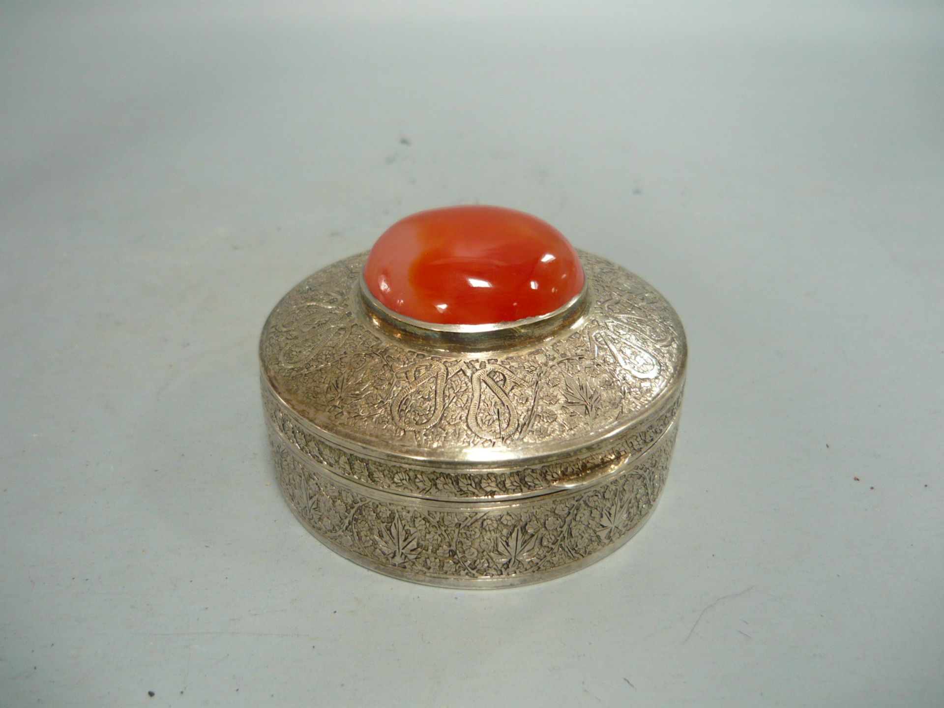 Sammelwürdige Silberdose mit eingesetztem Karneol. Silber über 750er). Ø 8cm, H. 4,5cm.