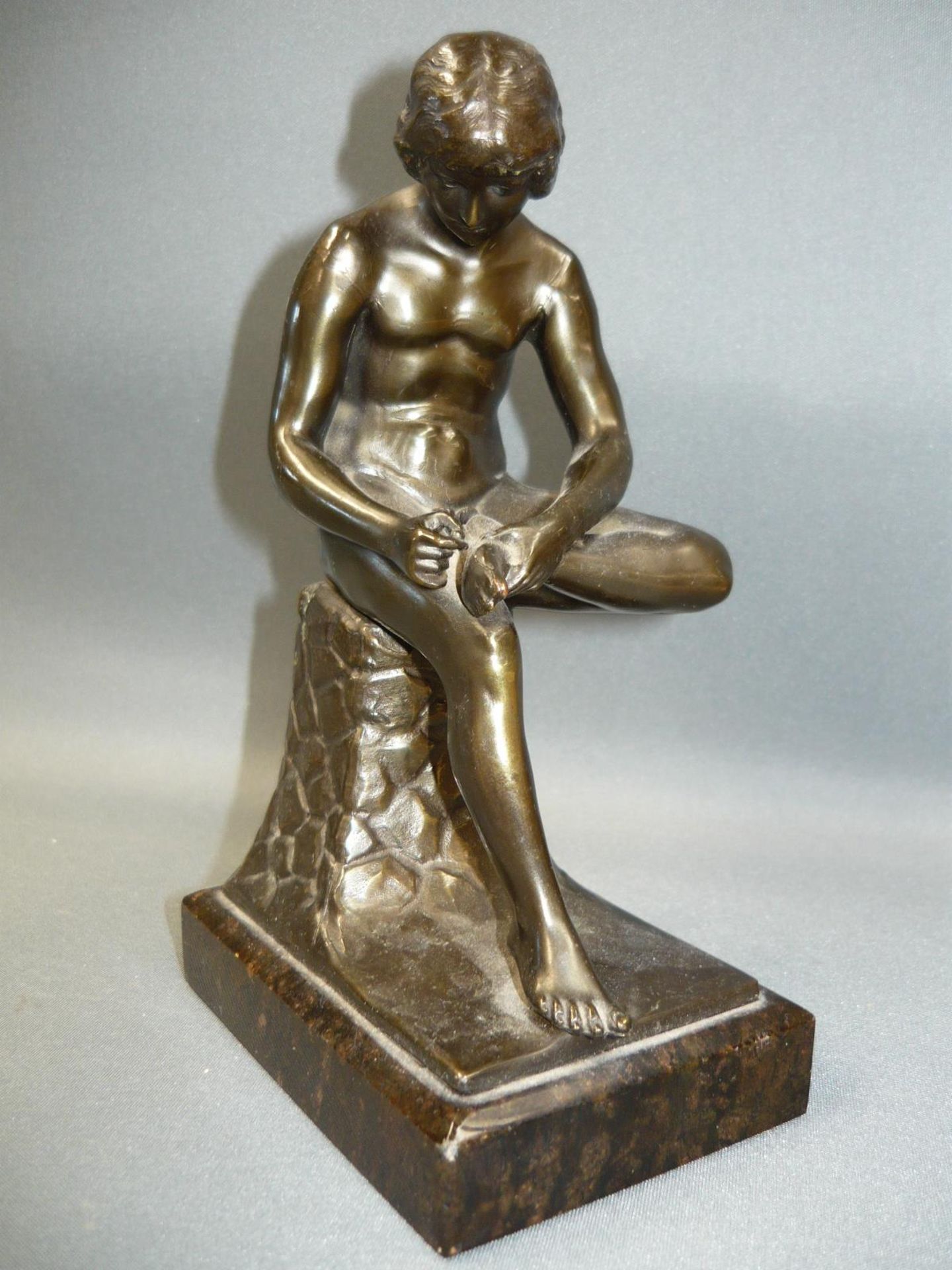 Rodin, nach. Der Dornenzieher. Metall auf Steinsockel. Wohl um 1920/50. H. 17cm.