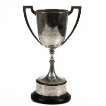 A silver two handled trophy cup, inscribed, on a ‘silver’ mounted plastic base, weight of weighab...