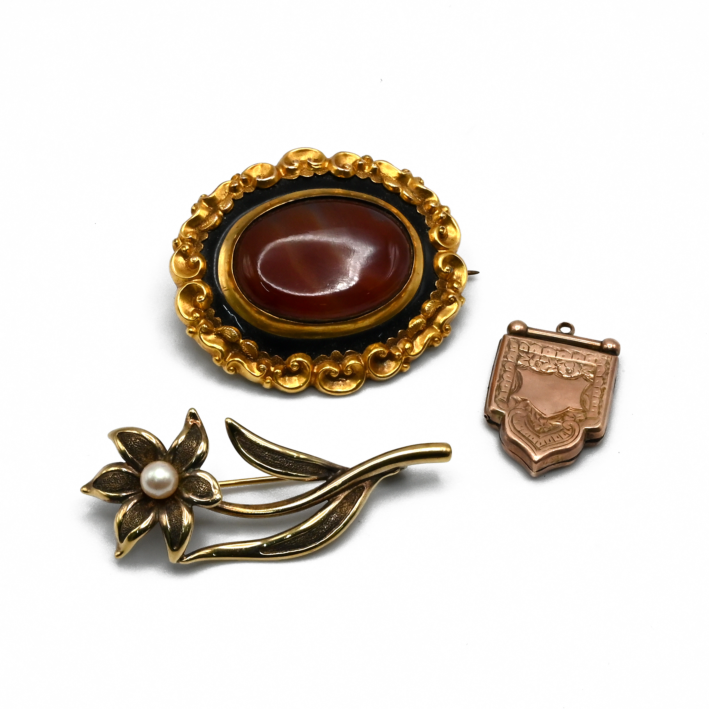 A 19th century agate set brooch, with black enamel border, C scroll and scroll border, 4.2cm long...