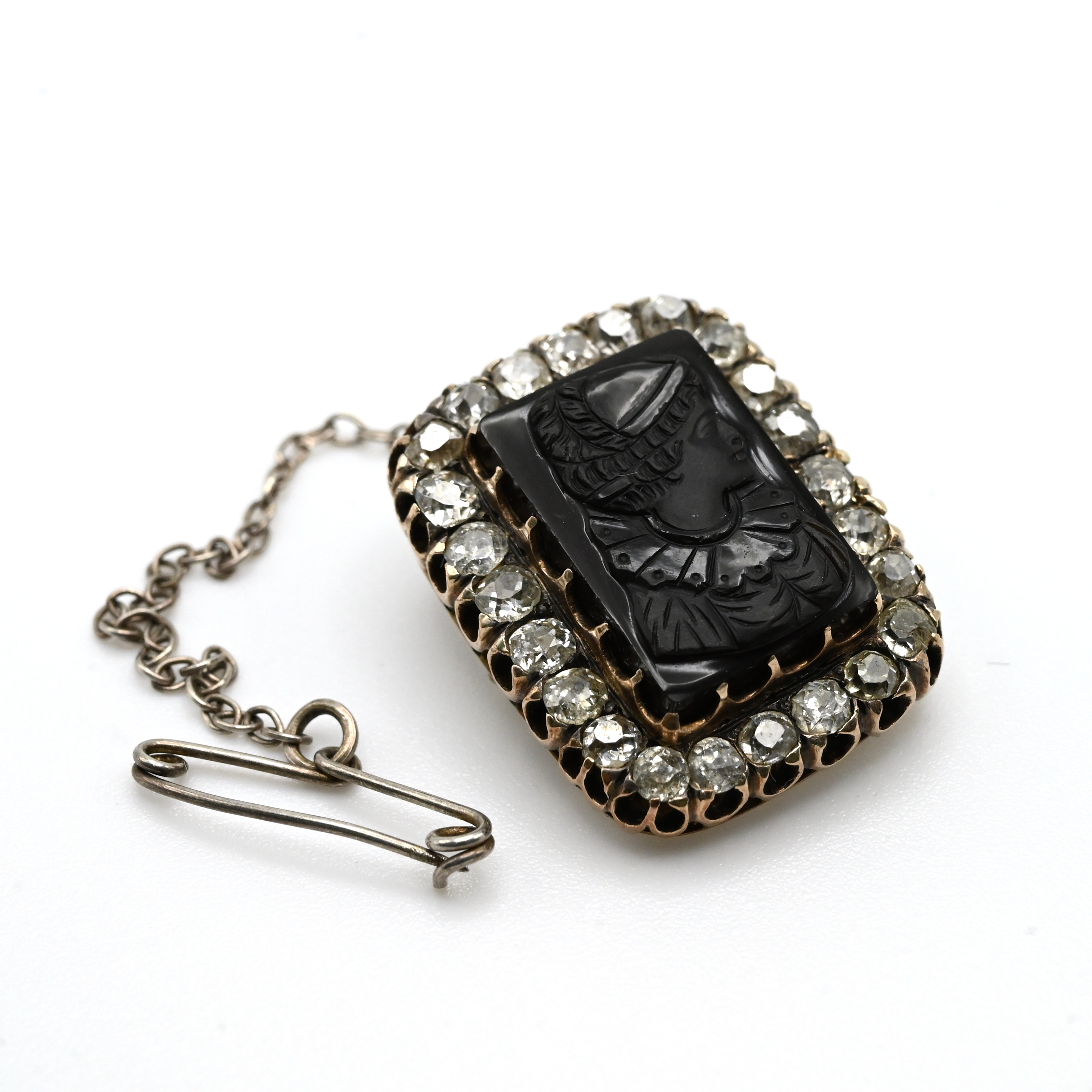A carved black onyx cameo and diamond brooch, circa 1900, the onyx measuring 1.7cm by 1.1cm, encl...