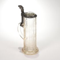 A clear glass faceted beer mug with etched decoration of deer in a forest landscape. Pewter lid w...