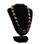 A row of oval dark cherry amber style beads necklace, 61 grams.