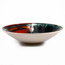 A 1970's Poole Pottery bowl, model number 57, abstract glazed in red, amber, blue, green and blac...