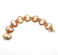 A shell cameo bracelet, the seven oval panels mounted ion yellow metal, stamped ‘K14’ to the catc...