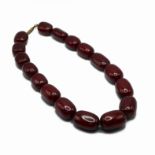 A row of large oval dark opaque cherry amber style beads, 132 grams.