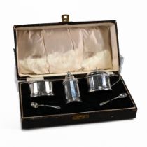 A cased three piece silver cruet set, W. Neale Ltd, Birmingham 1933, of round panelled form with ...