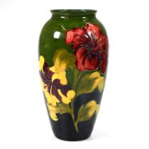 A large (32cm) Moorcroft Hibiscus pattern vase with tube lined floral decoration on green ground ...