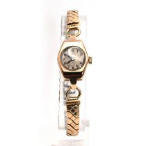 Dot, a lady’s 9 carat gold mechanical wrist watch on a metal expanding bracelet.