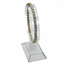 A diamond line bracelet, stamped ‘375’, set with thirty nine small brilliant cuts, totalling 0.95...