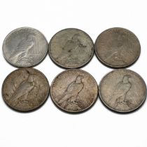 A group of six United States 'Peace' dollars (which were minted between 1921 and 1935 and are mad...