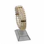 A uniform three row cultured pearl bracelet, with textured yellow metal dividers and catch, the
l...