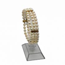 A uniform three row cultured pearl bracelet, with textured yellow metal dividers and catch, the l...