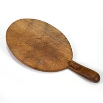 An oval carved oak cheese board with the Robert "Mouseman" Thompson mouse carved into the handle....