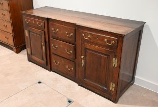 An early 19th Century oak inverted breakfront sideboard. Three central drawers flanked by large c...