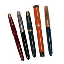 Five Parker pens including an orange Duofold "Lucky Curve", a Duofold Junior in green (circa 1965...