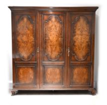 An Edwardian (c1910) triple Wardrobe with quarter matched Burr Walnut and string inlay doors. Int...