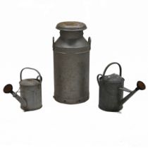 An galvanised milk churn with lid, "United Dairies", 74cm high, 35cm diameter, along with two gal...