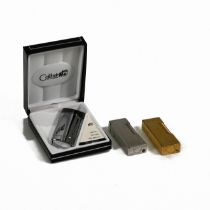 A engine turned Dunhill lighter, along with a gold plated Dunhill lighter and a Colibri Elite col...