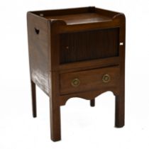 A Georgian mahogany night stand with galleried top over a tambour door opening to reveal a cupboa...