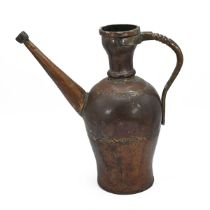 A Middle Easter hammered copper water jug with pronounced brass handle and long angled spout. H 3...