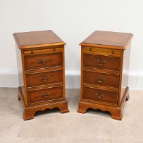 A pair of Bradley yew wood bedside cabinets each with three drawers, with brass swan neck handles...