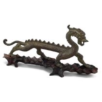 A Chinese bronze model of a dragon, on a fitted hardwood stand, 30cm long, 14cm high