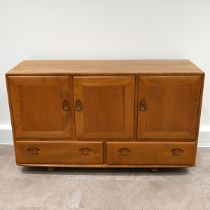 Ercol Windsor light elm sideboard, fitted with three cupboards over two drawers all with carved o...
