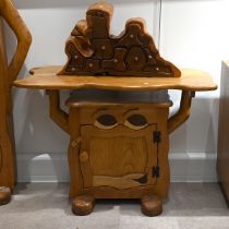 A late 20th century carved oak character side table with cabinet under. The cabinet having carved...