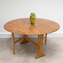 A Mid-Century Ercol Blonde elm and beech Model 610 drop leaf Sutherland oval dining table. Part o...