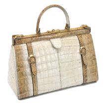 A vintage cream and brown crocodile skin handbag, with a brass push lock and straps and having su...