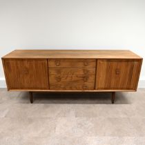 An Ensign Elm sideboard by Bristow and Townsend comprising four long drawers flanked by cupboards...